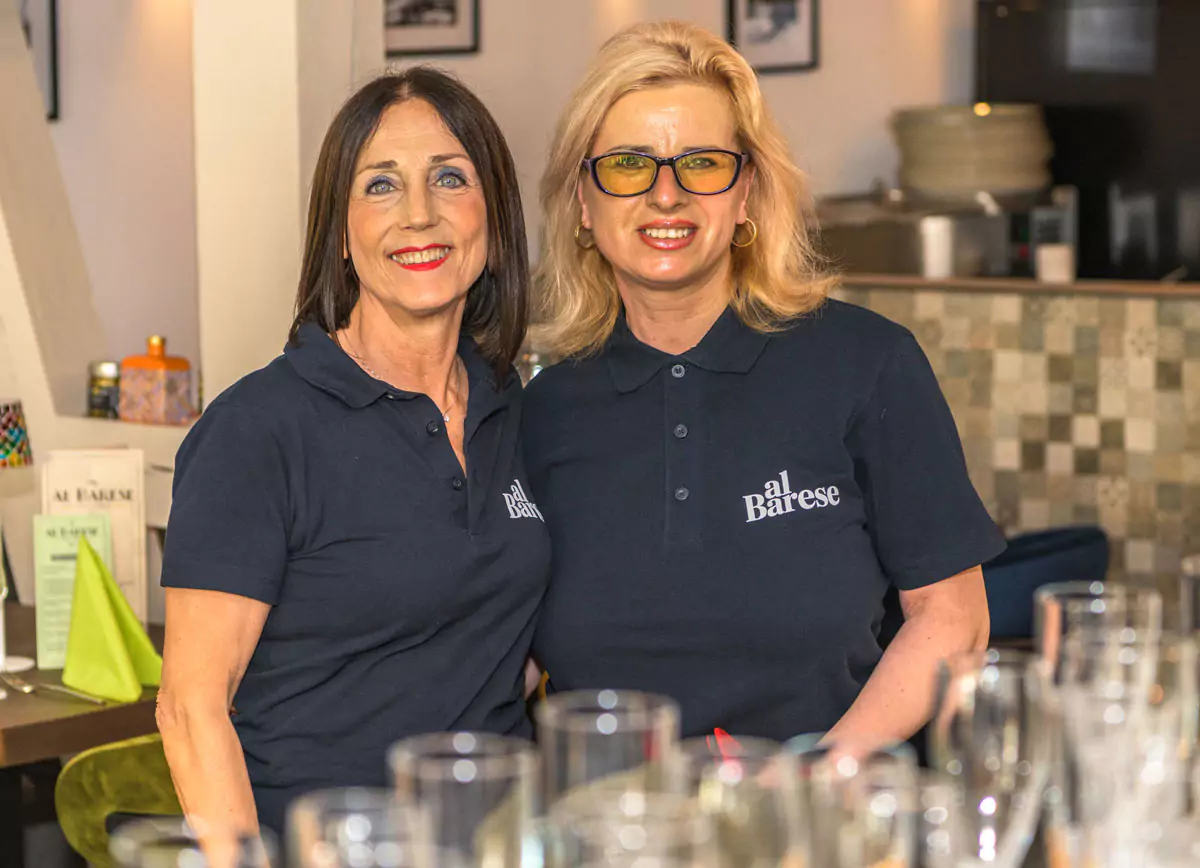 2 Damen stehen zusammen hinter dem Tresen des Restaurants