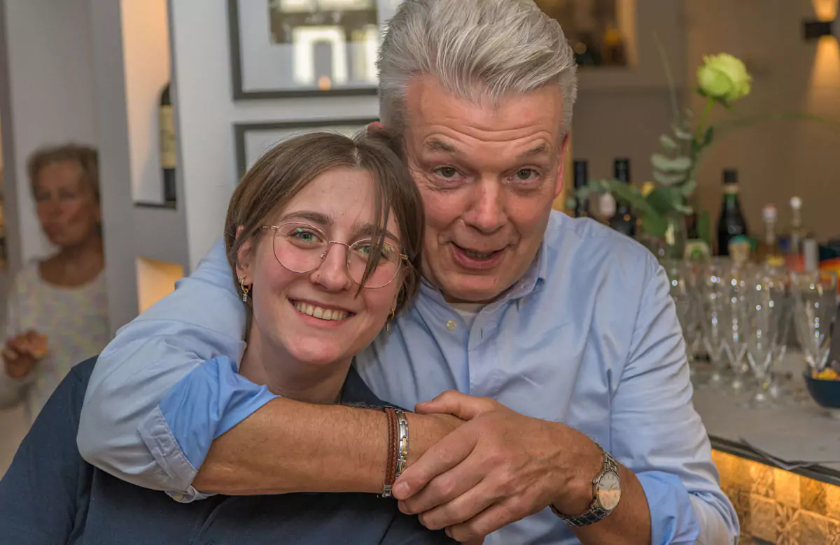 älterer Herr mit einer jungen Frau lächelnn in die Kamera