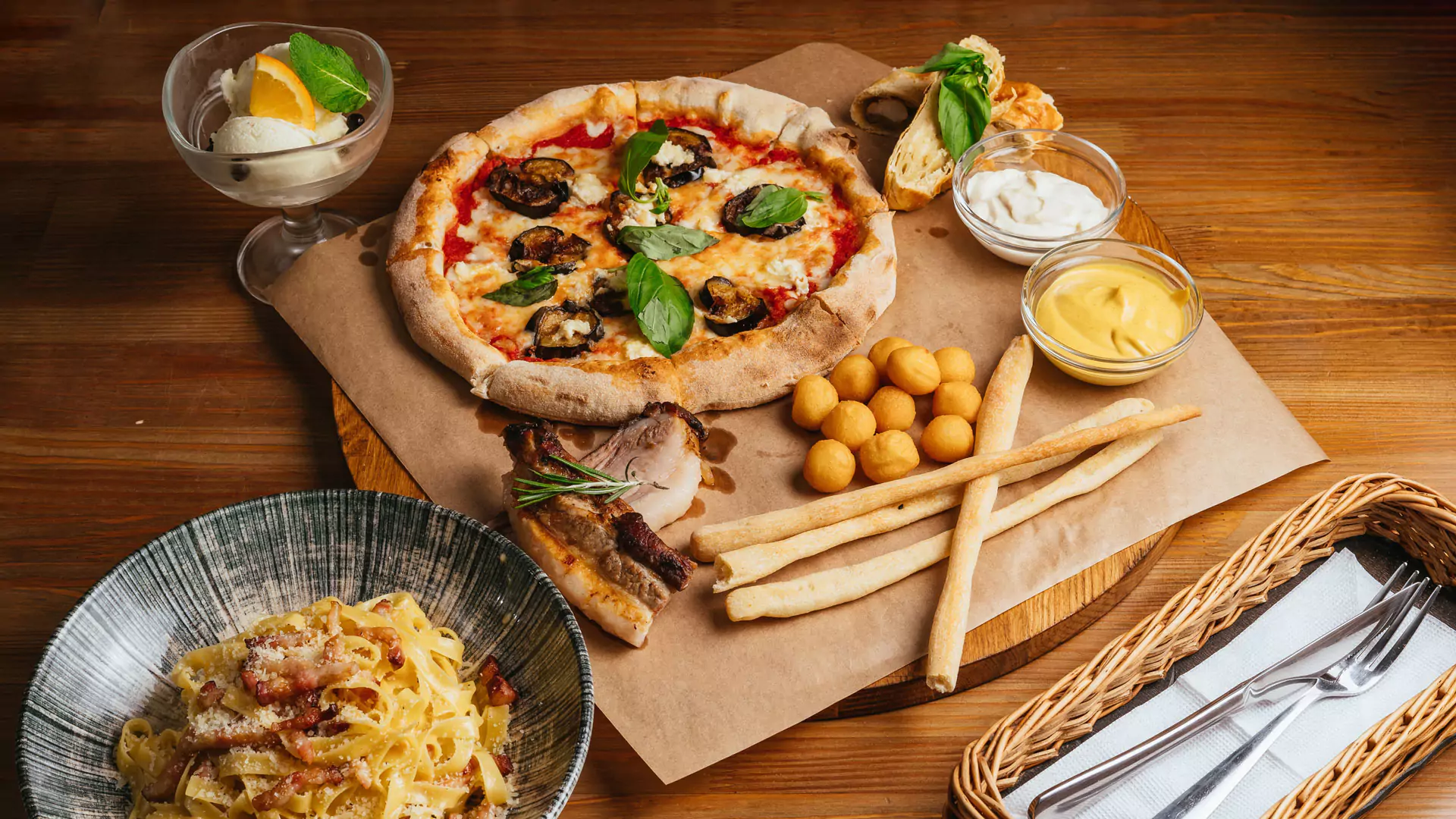 Speisen im italienischen Restaurant v.l.n.r.: Spaghetti alla carbonara, Gelato al limone, Pizza Magaritha mit Auberginenscheiben, Dips, geräucherte Käsebällchen, Grissini