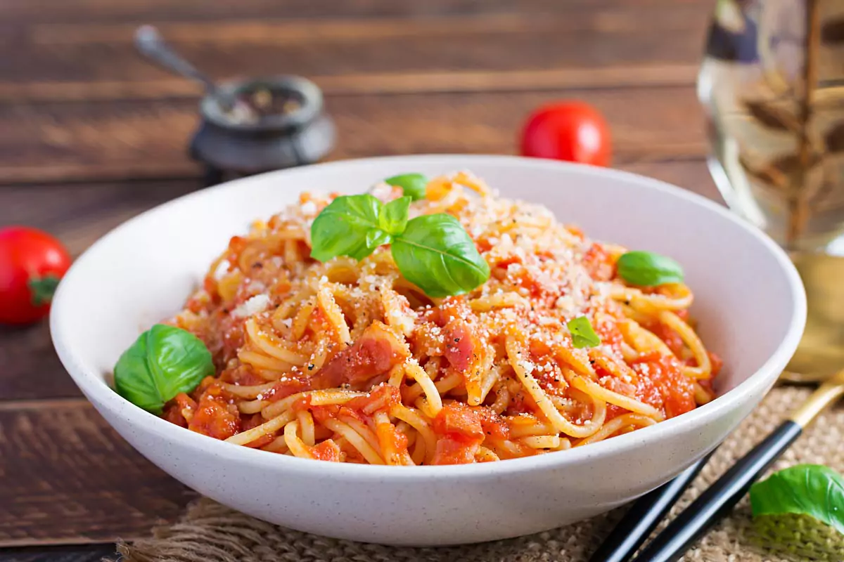 Spaghetti mit Tomatensauce und Pecorino-Käse garniert mit Basilikum Blättern