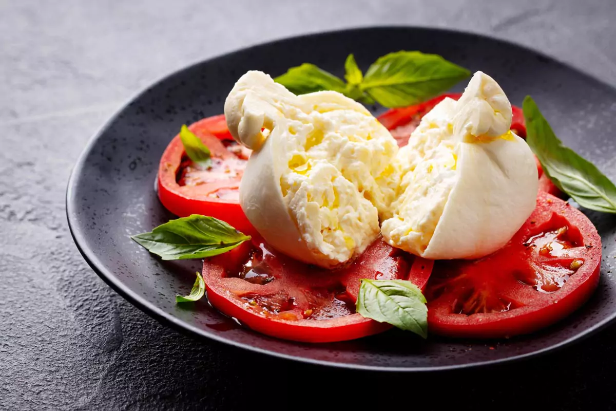 Caprese-Salat mit Tomaten, Burrata-Käse und frischem Basilikum.